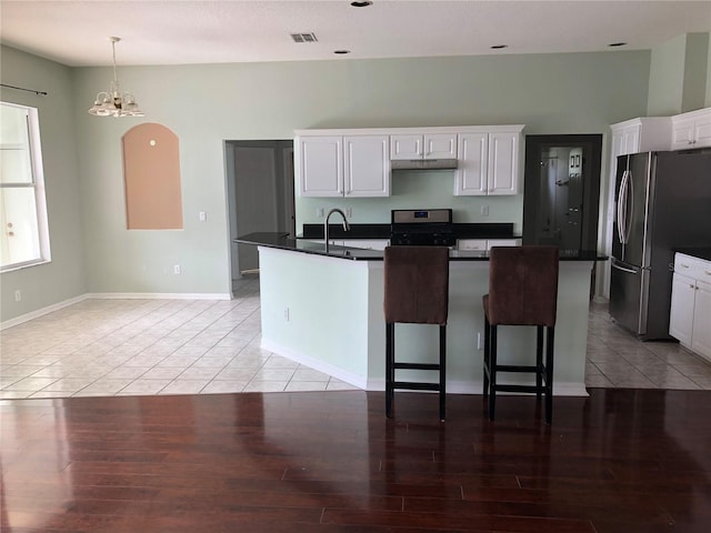 4512 River Overlook Dr, Valrico, FL 33596 - kitchen with stainless steel refrigerator with ice dispenser, gas stove, under cabinet range hood, a chandelier, and dark countertops