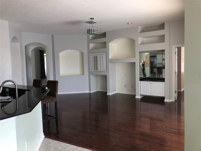 4512 River Overlook Dr, Valrico, FL 33596 - living area featuring wood finished floors, a textured ceiling, arched walkways, and baseboards