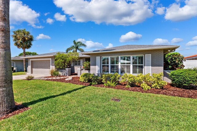 3912 Doral Dr, Tampa, FL 33634 - ranch-style house with brick siding, driveway, a garage, and a front yard