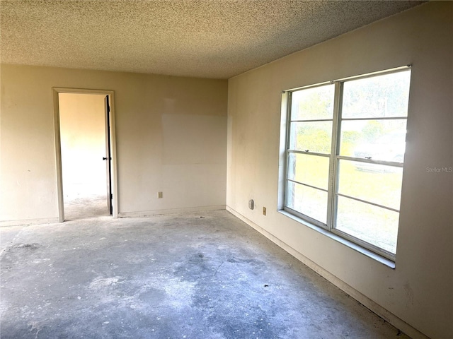 9722 Kenton Rd, Wesley Chapel, FL 33545 - unfurnished room with unfinished concrete flooring, a textured ceiling, and plenty of natural light