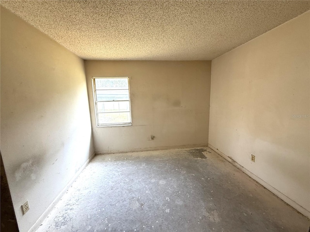 9722 Kenton Rd, Wesley Chapel, FL 33545 - spare room with a textured ceiling, baseboards, and concrete flooring