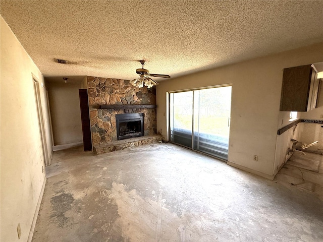 9722 Kenton Rd, Wesley Chapel, FL 33545 - unfurnished living room featuring ceiling fan, baseboards, a fireplace, a textured ceiling, and unfinished concrete flooring
