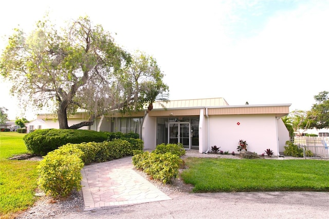 rear view of house featuring stucco siding
