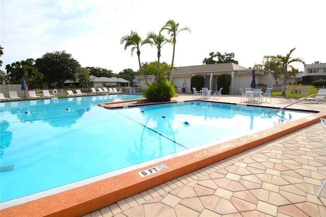 community pool featuring fence and a patio area