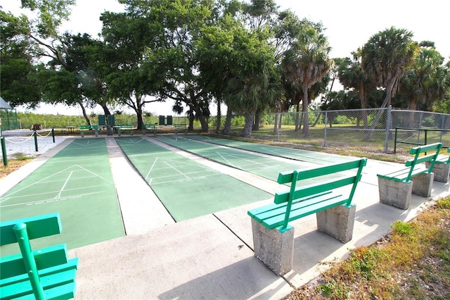 view of community featuring shuffleboard and fence