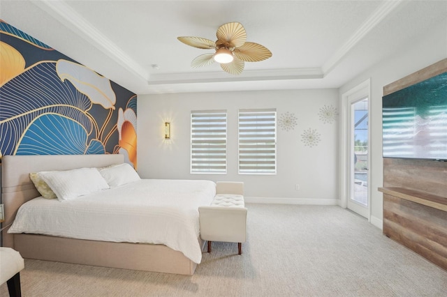 bedroom featuring a raised ceiling, access to exterior, multiple windows, ceiling fan, and ornamental molding