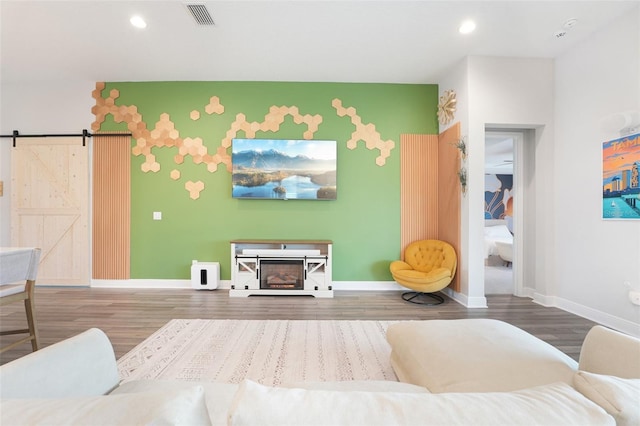 living room featuring wood finished floors, baseboards, recessed lighting, a barn door, and a fireplace