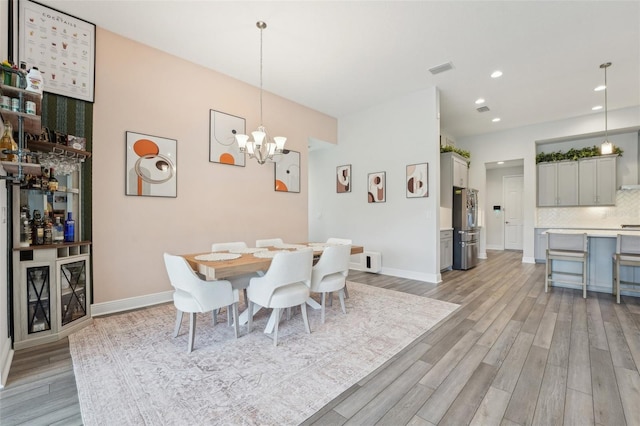 dining area with light wood-style flooring, a chandelier, recessed lighting, and baseboards