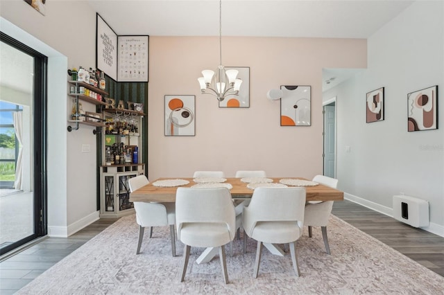 dining room featuring dark wood-style flooring, a chandelier, and baseboards
