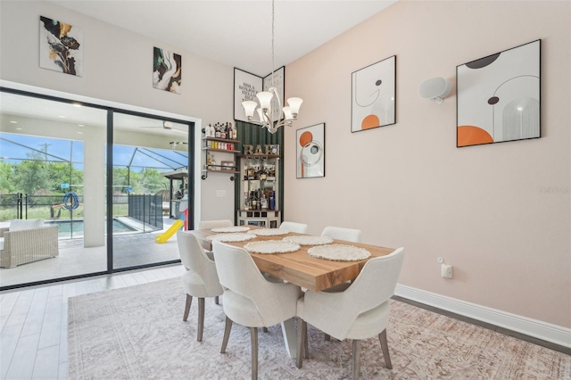 dining area with a chandelier, wood finished floors, and baseboards