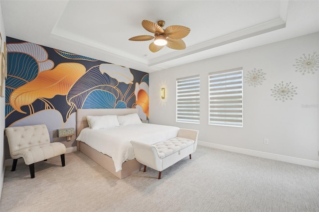 carpeted bedroom featuring a raised ceiling, baseboards, and ceiling fan