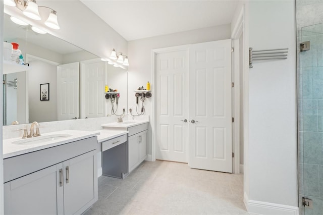 bathroom with vanity, tiled shower, tile patterned floors, and baseboards