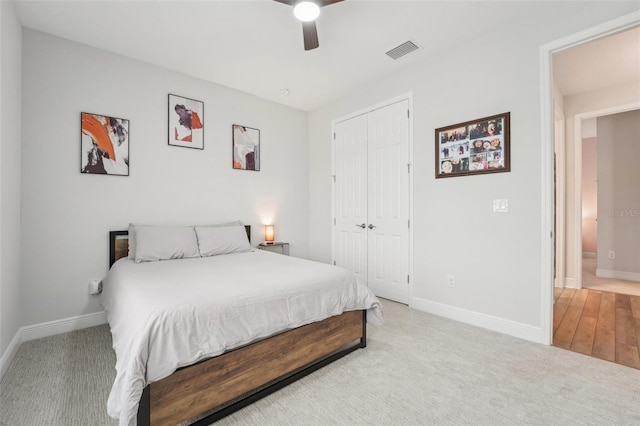 bedroom featuring a closet, baseboards, a ceiling fan, and light carpet