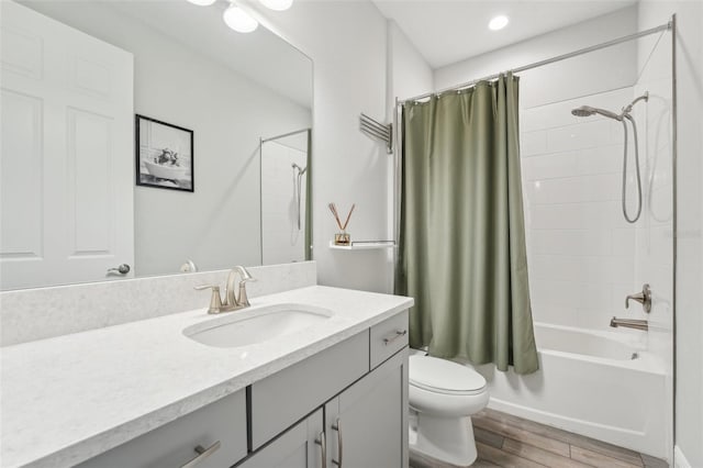 bathroom featuring toilet, wood finished floors, vanity, and shower / bath combo