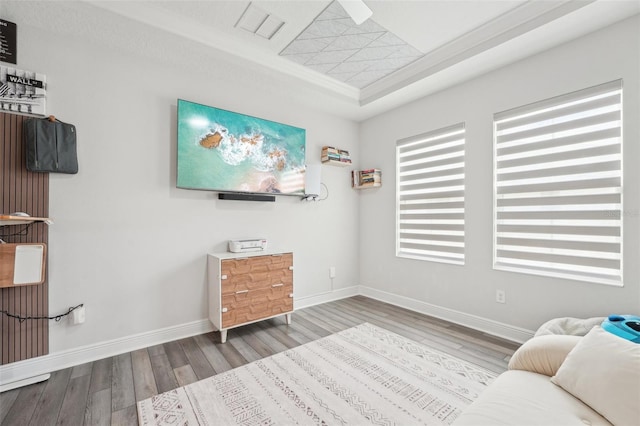 sitting room with wood finished floors, baseboards, and a tray ceiling