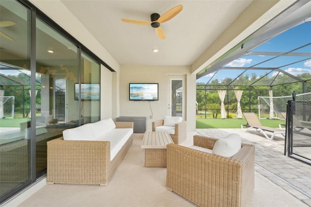 view of patio featuring ceiling fan, an outdoor hangout area, and glass enclosure