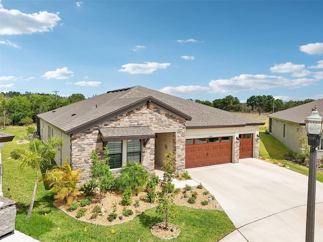 view of front facade with stone siding, a garage, concrete driveway, a front lawn, and a shingled roof