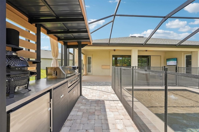 view of patio / terrace featuring an outdoor kitchen, a lanai, a grill, and ceiling fan