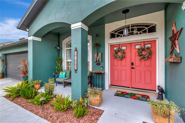 5103 Rushbrook Rd, Land O Lakes, FL 34638 - view of exterior entry featuring stucco siding, a porch, and a garage