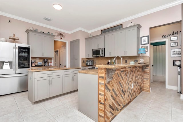 5103 Rushbrook Rd, Land O Lakes, FL 34638 - kitchen with stainless steel appliances, gray cabinetry, a peninsula, decorative backsplash, and light tile patterned floors