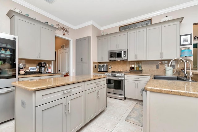 5103 Rushbrook Rd, Land O Lakes, FL 34638 - kitchen with appliances with stainless steel finishes, a sink, backsplash, a kitchen island, and ornamental molding