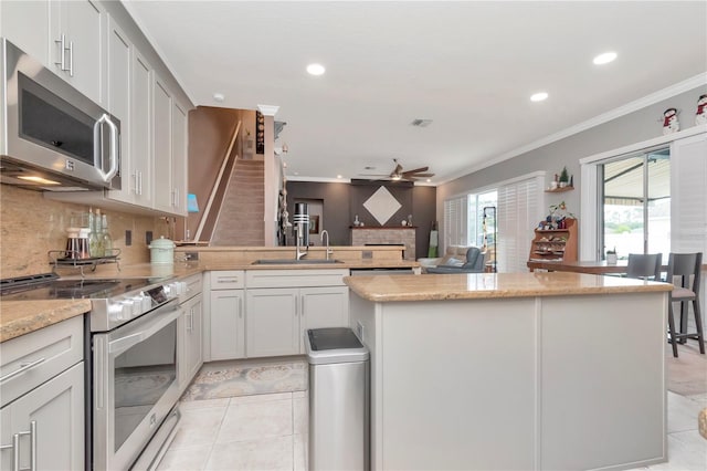 5103 Rushbrook Rd, Land O Lakes, FL 34638 - kitchen with appliances with stainless steel finishes, ceiling fan, recessed lighting, a peninsula, and light tile patterned floors