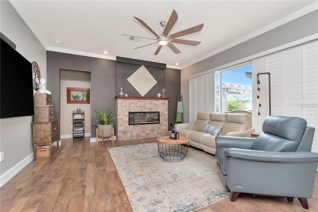 5103 Rushbrook Rd, Land O Lakes, FL 34638 - living room with ceiling fan, ornamental molding, a glass covered fireplace, wood finished floors, and recessed lighting
