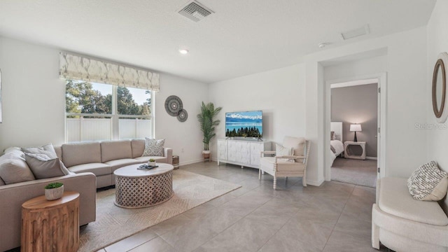 living area featuring light tile patterned floors, baseboards, and recessed lighting