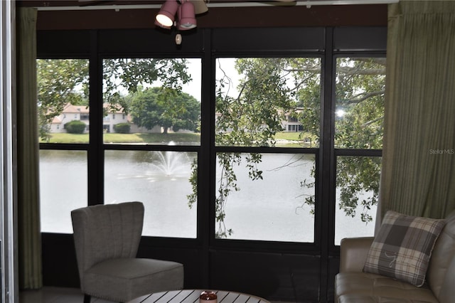 sunroom featuring a water view
