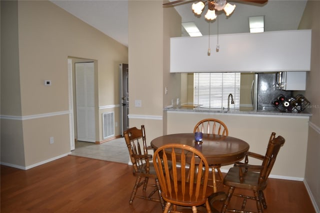 dining room featuring a ceiling fan, wood finished floors, lofted ceiling, and baseboards
