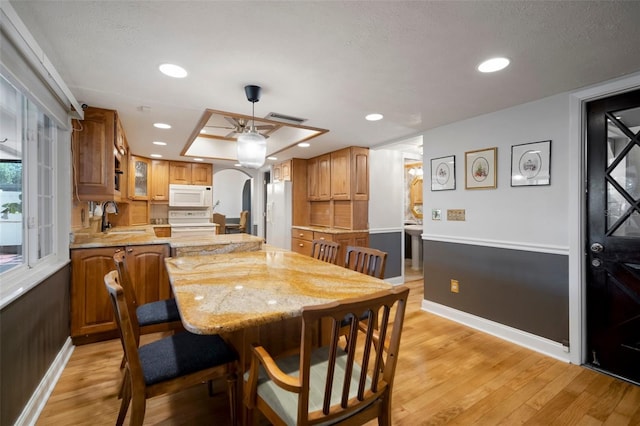 dining room featuring baseboards, light wood-style floors, arched walkways, ceiling fan, and recessed lighting