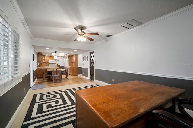 office area featuring ceiling fan, ornamental molding, and baseboards