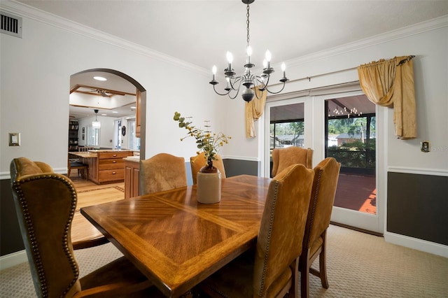 dining space with arched walkways, crown molding, a chandelier, and baseboards