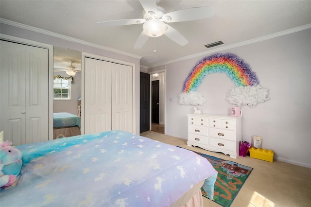 bedroom featuring two closets, carpet, crown molding, and ceiling fan
