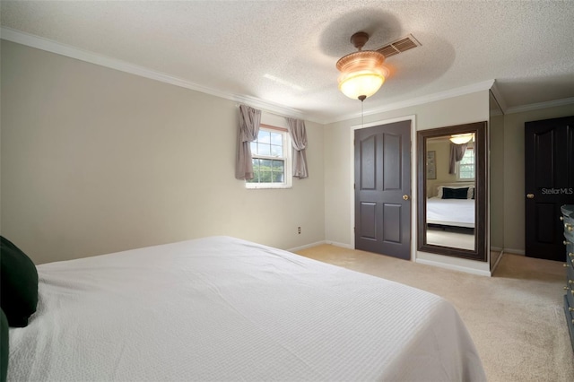 carpeted bedroom featuring ornamental molding, a textured ceiling, ceiling fan, and baseboards