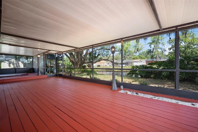 unfurnished sunroom with a deck with water view and hardwood / wood-style flooring