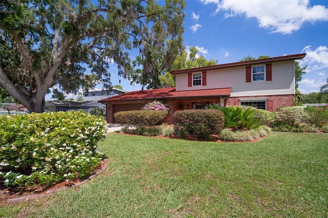 traditional home with an attached garage, a front yard, and brick siding