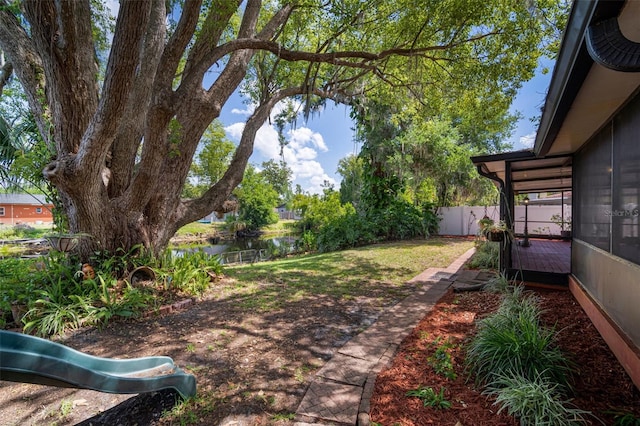 fenced backyard featuring a water view
