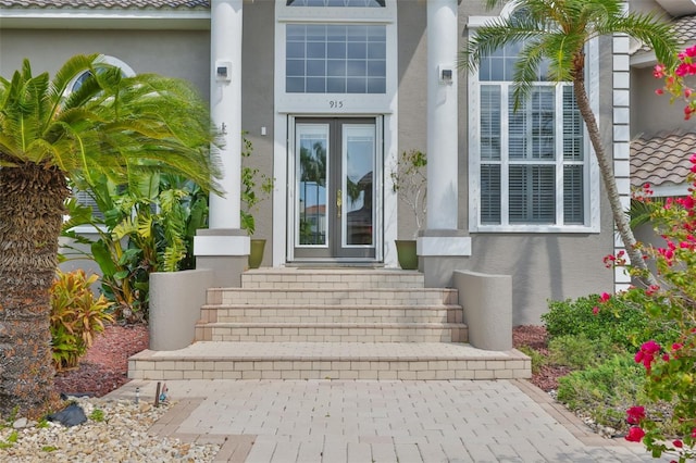 entrance to property featuring stucco siding and french doors