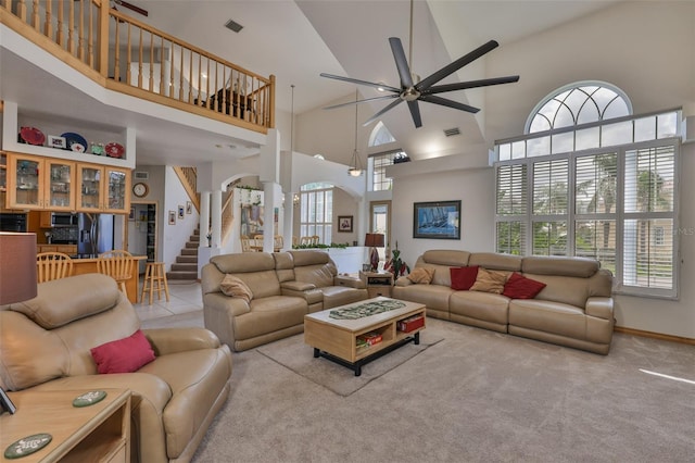 living room featuring a ceiling fan, high vaulted ceiling, carpet floors, stairway, and baseboards