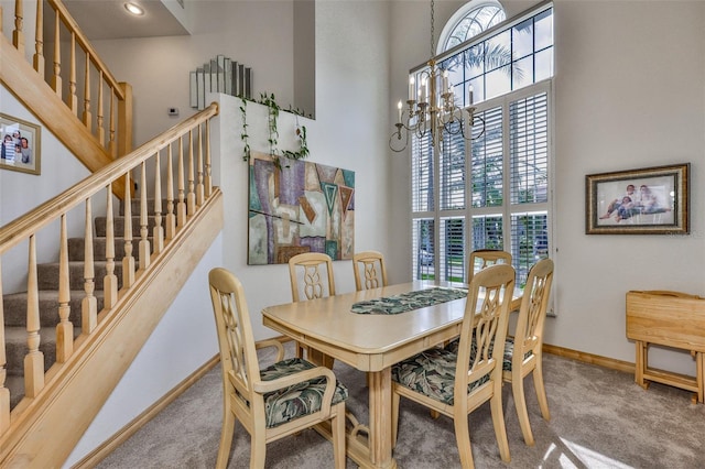 dining space with carpet, a chandelier, a high ceiling, baseboards, and stairway