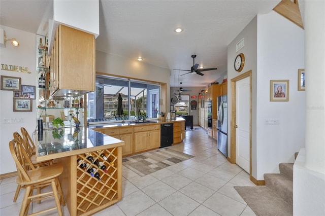 kitchen with a peninsula, dishwasher, a sink, ceiling fan, and light tile patterned flooring
