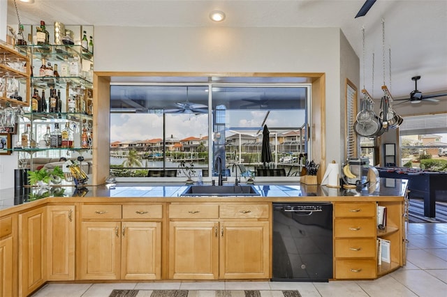 kitchen featuring a ceiling fan, a sink, black dishwasher, and tile counters