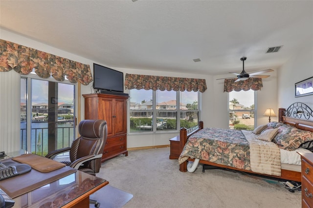 bedroom with access to outside, carpet floors, multiple windows, and a ceiling fan