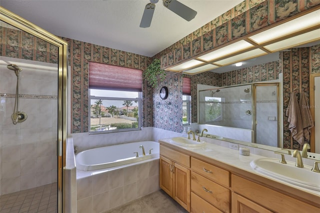 bathroom with a bath, a stall shower, wallpapered walls, double vanity, and a ceiling fan