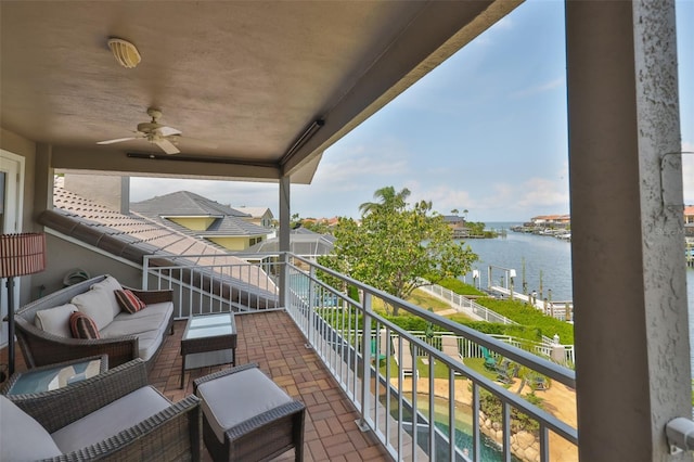 balcony featuring a water view and ceiling fan