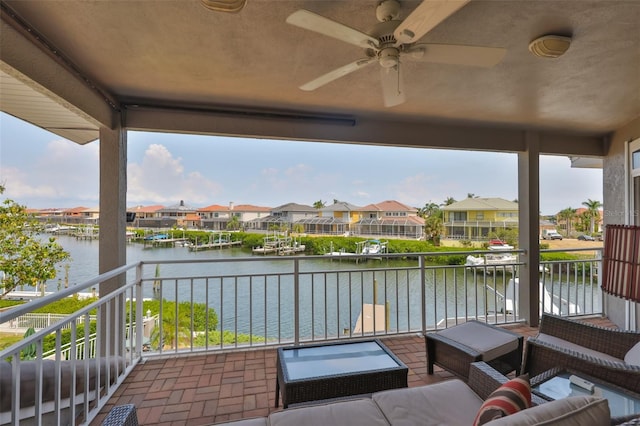 view of patio / terrace with a water view, a ceiling fan, a balcony, and a residential view