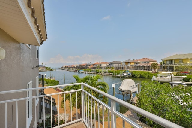 balcony with a water view, a residential view, and a dock