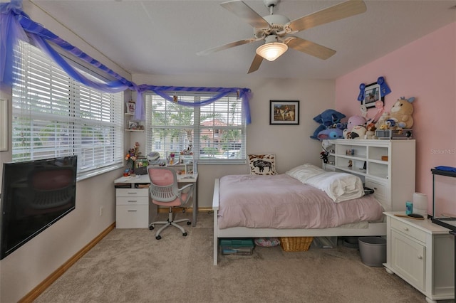 bedroom with light colored carpet, baseboards, a desk, and ceiling fan