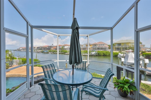 sunroom featuring a water view and a residential view